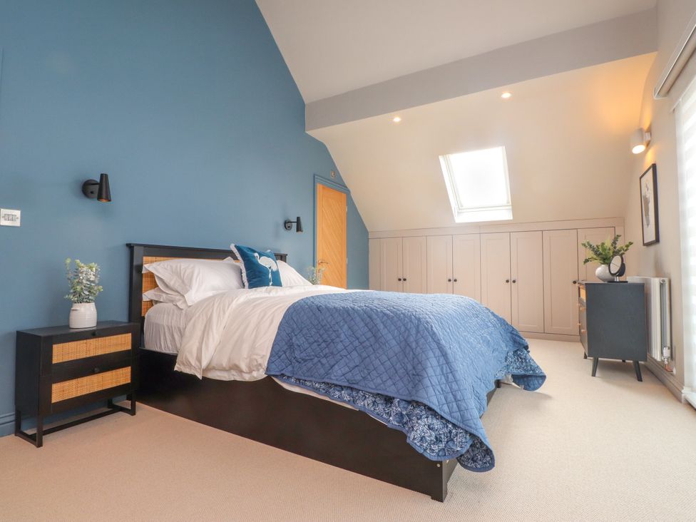 A bedroom with a bed and nightstand at Ardwyn Rhosneigr