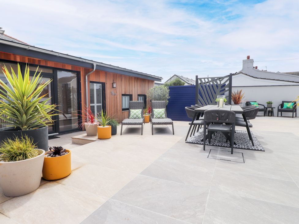 An outdoor patio with seating and planters at Ardwyn in Rhosneigr