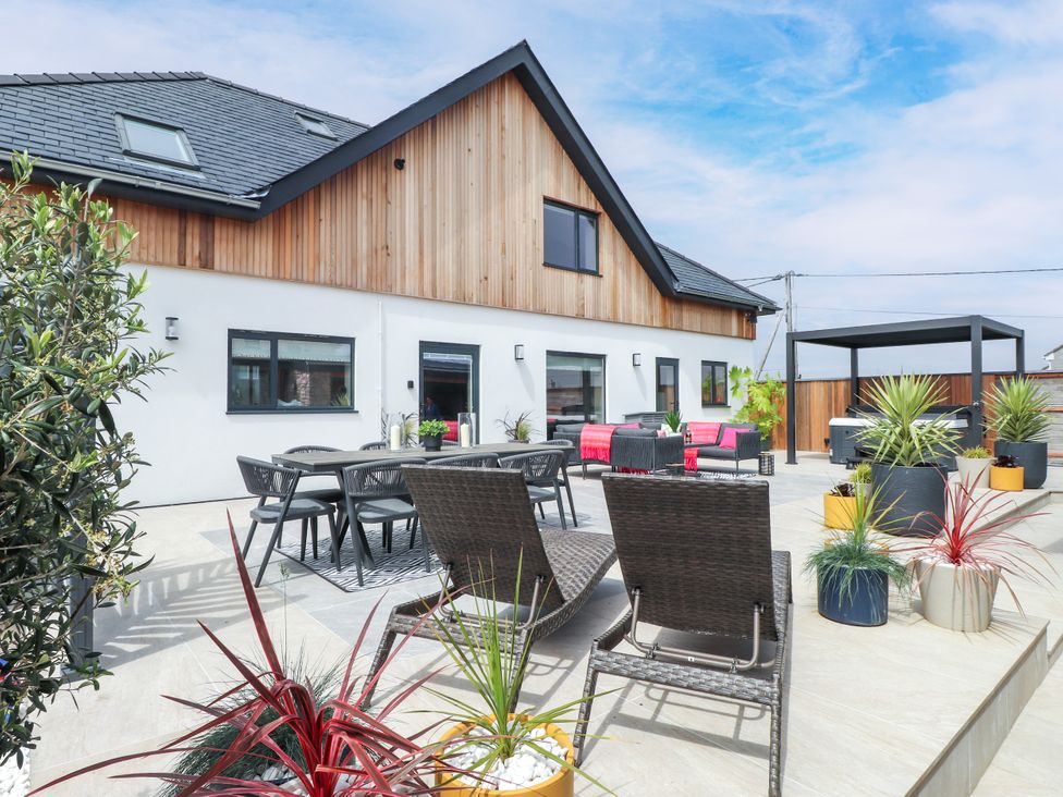 An outdoor patio with furniture and plants at Ardwyn in Rhosneigr