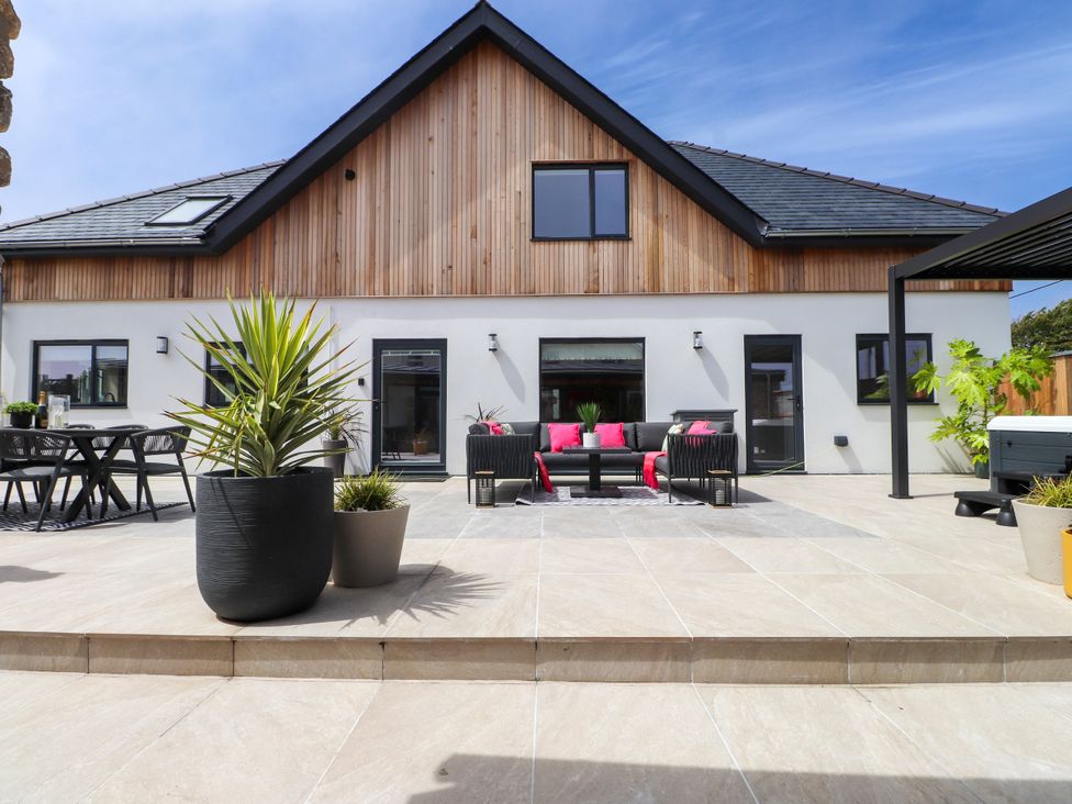 An outdoor seating area with a table and chairs at Ardwyn Rhosneigr