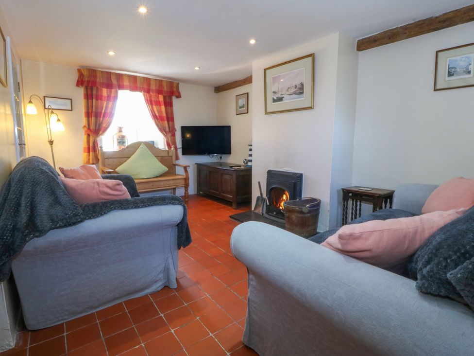 A living room with a sofa and television at Brynffynon in Pwllheli