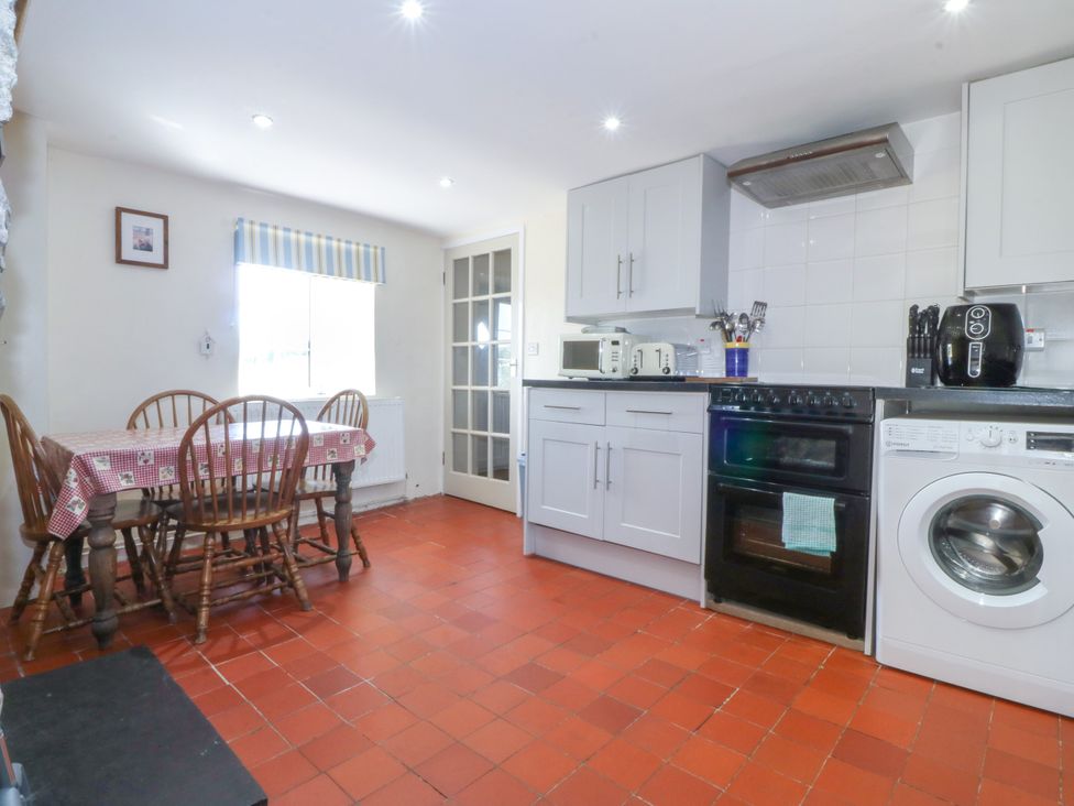 A kitchen with a table and chairs at Brynffynon in Pwllheli