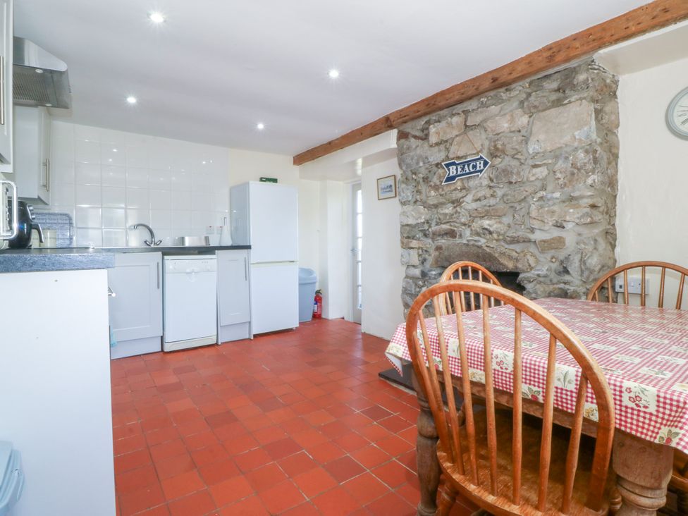 A kitchen with a table and chairs at Brynffynon in Pwllheli