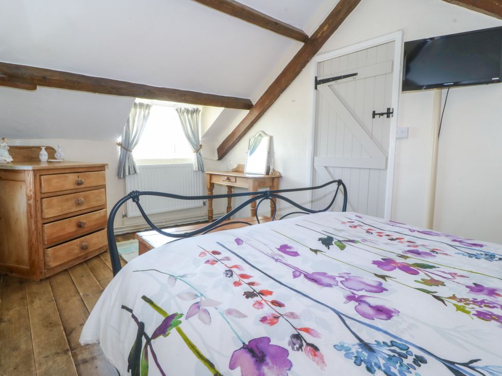 A bedroom with a bed and dresser at Brynffynon in Pwllheli