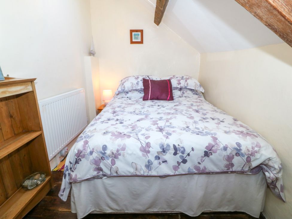 A bedroom with a bed and a bedside lamp at Brynffynon in Pwllheli