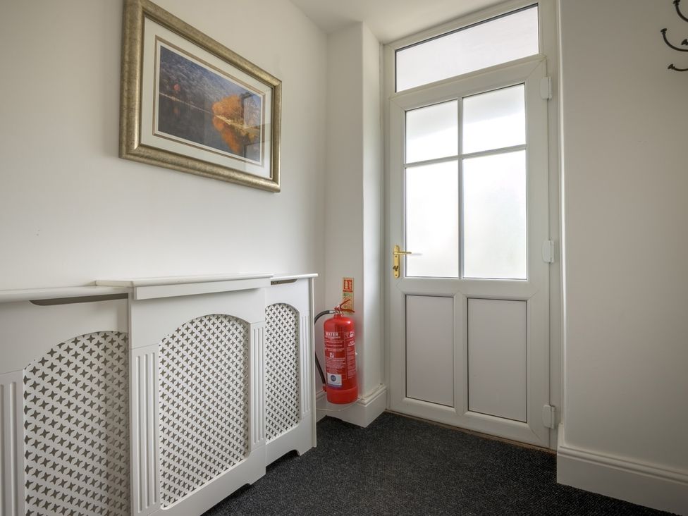 A hallway with a door and radiator cover at Moss Crag in Glenridding