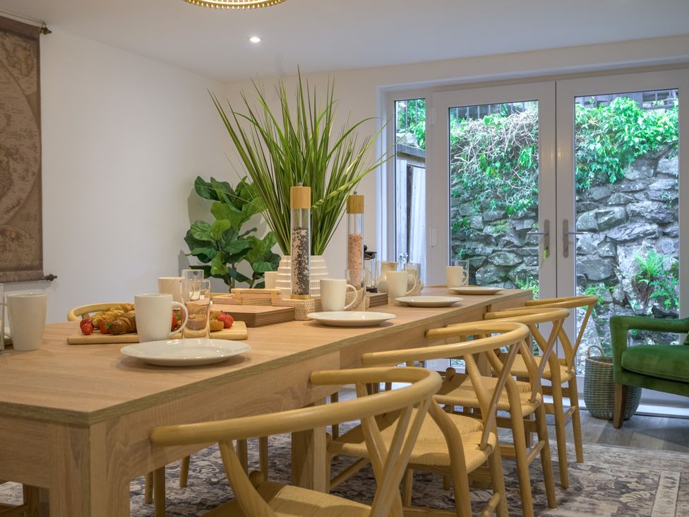 A dining room with a table set for a meal at Moss Crag in Glenridding