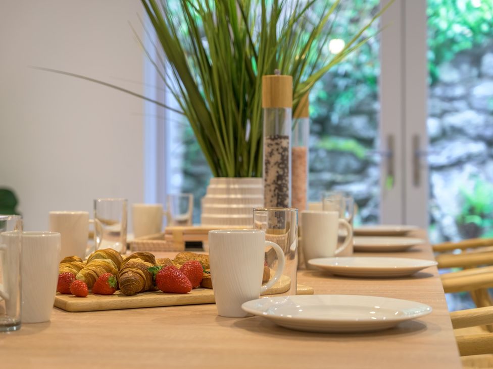 A dining room table set with plates and food at Moss Crag in Glenridding