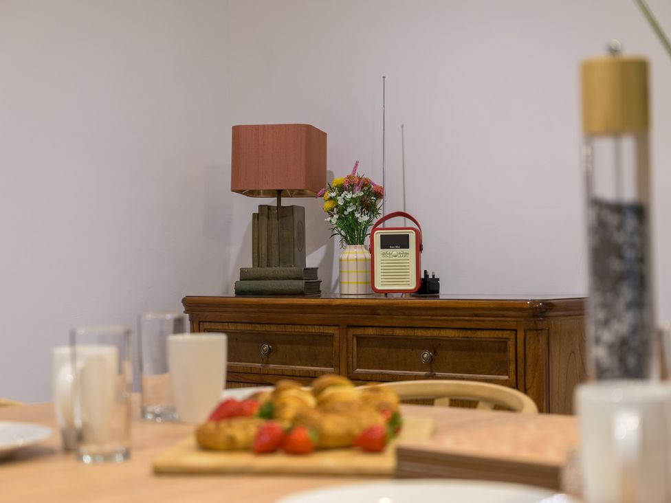 A dining room with a lamp and radio on a cabinet at Moss Crag in Glenridding