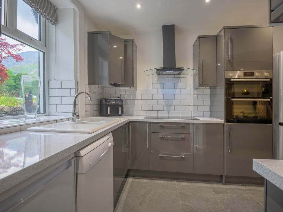 A kitchen with modern cabinets and appliances at Moss Crag in Glenridding