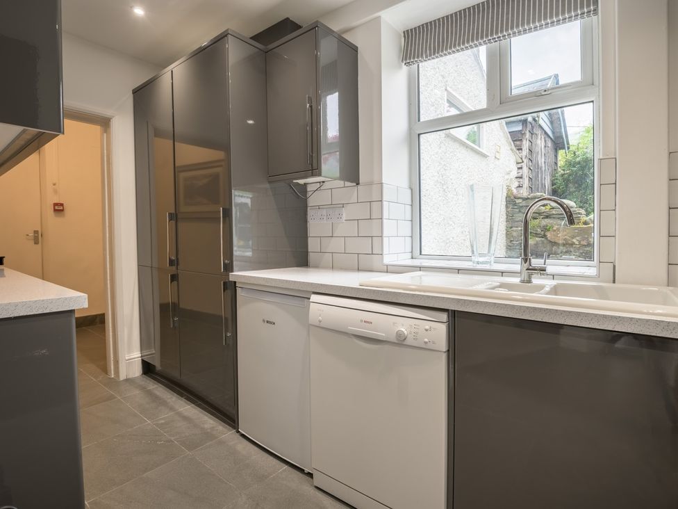 A kitchen with cabinets, sink and dishwasher at Moss Crag in Glenridding