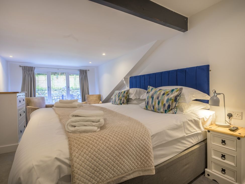 A bedroom with beds and a window at Moss Crag in Glenridding