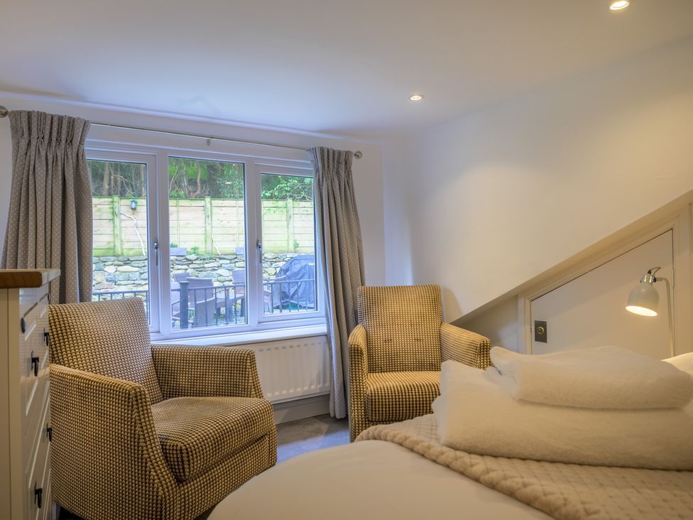 A bedroom with two chairs and a window at Moss Crag in Glenridding