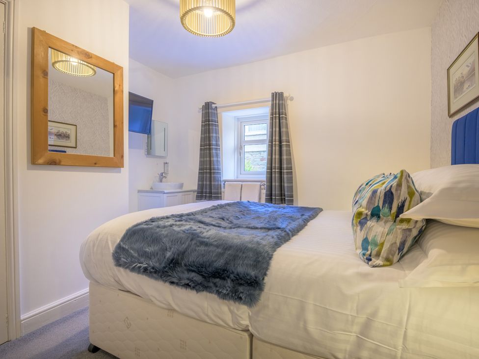 A bedroom with a bed and a sink at Moss Crag in Glenridding