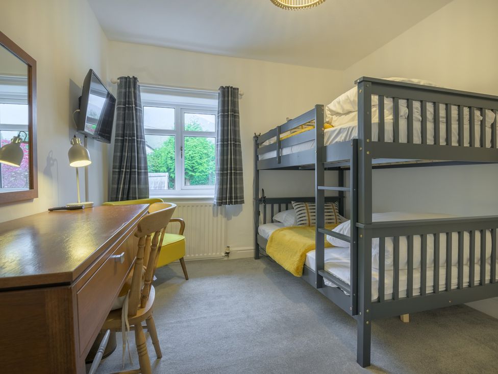 A bedroom with a bunk bed and a desk at Moss Crag in Glenridding