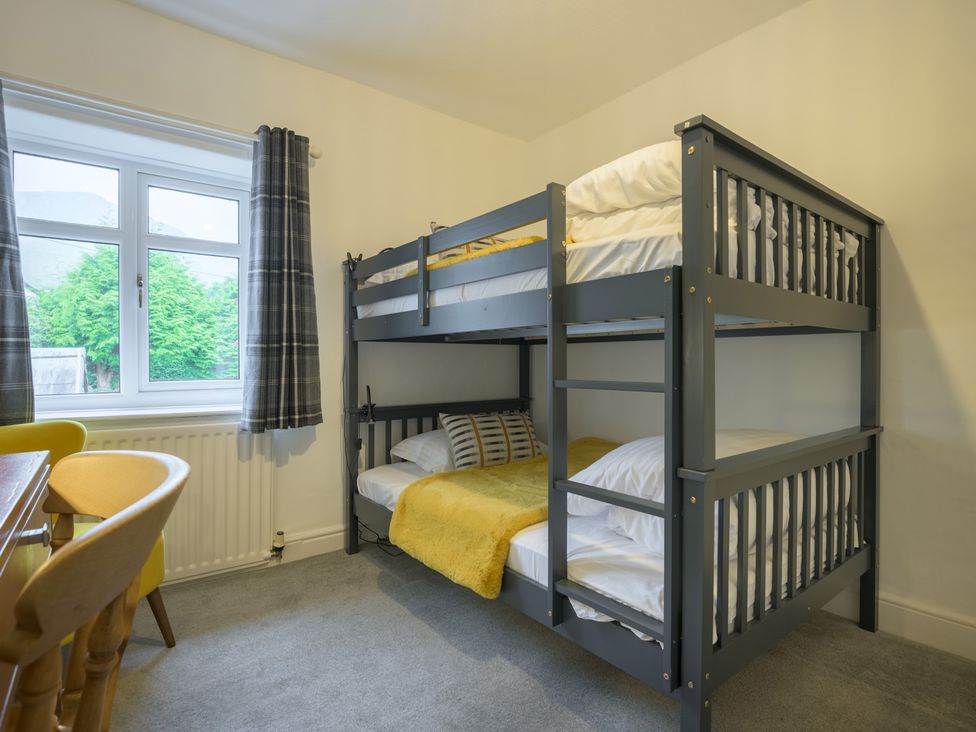 A bedroom with a bunk bed and a table at Moss Crag in Glenridding