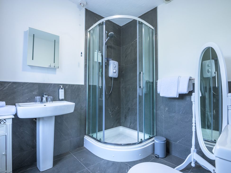 A bathroom featuring a sink, shower, mirror, and towels at Moss Crag in Glenridding
