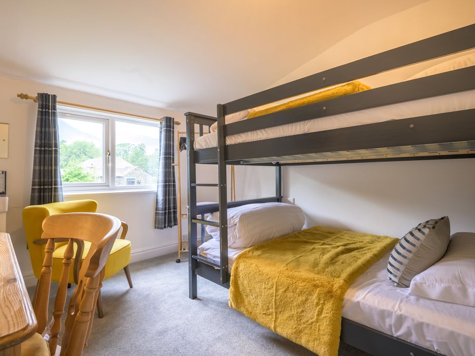 A bedroom with a bunk bed and a single bed at Moss Crag in Glenridding