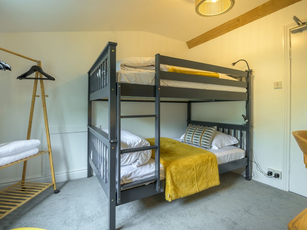 A bunk bed with yellow blanket and towels at Moss Crag in Glenridding