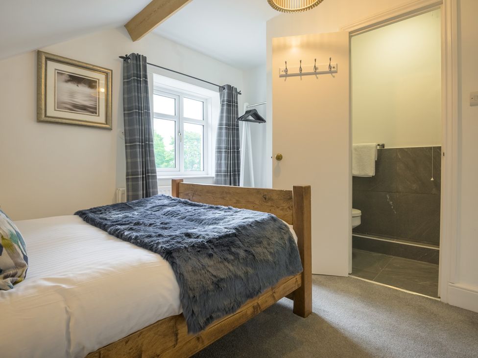 A bedroom with a bed and attached bathroom at Moss Crag in Glenridding