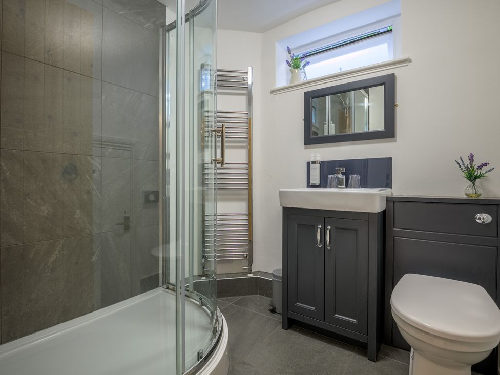 A bathroom with a shower, toilet, and sink at Moss Crag in Glenridding
