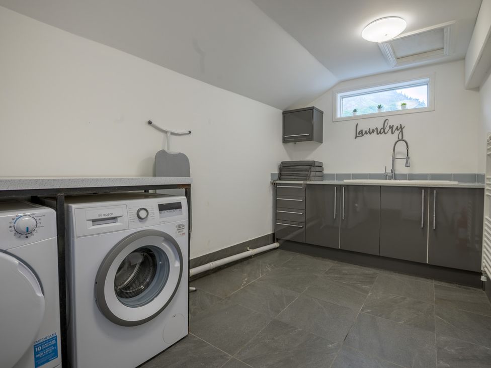A laundry room with a washing machine and cabinets at Moss Crag in Glenridding