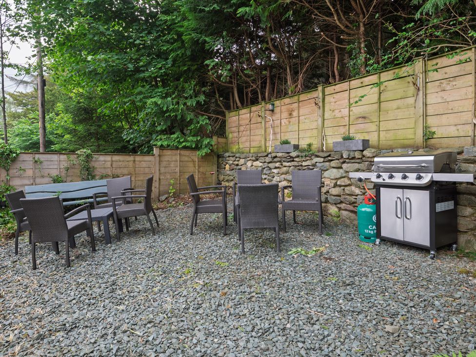 A garden with outdoor seating and a grill at Moss Crag in Glenridding