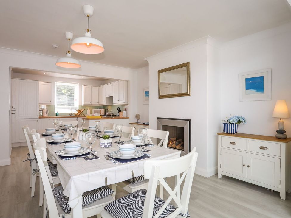 A dining room with a table set for meals at 15 Llwyn Gwalch Estate in Pwllheli