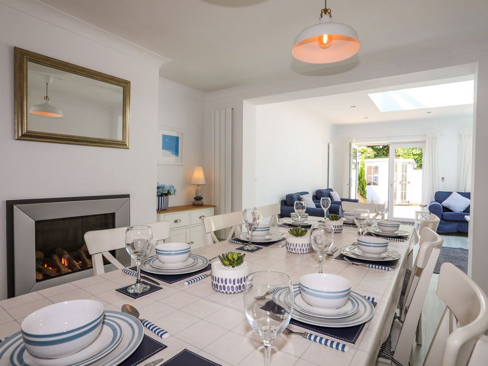 A dining room with a table set for meals at 15 Llwyn Gwalch Estate in Pwllheli
