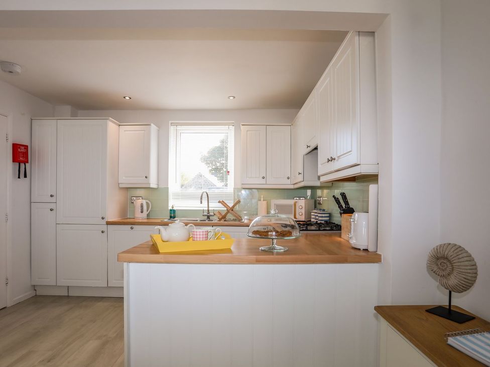 A kitchen with cabinets and countertop at 15 Llwyn Gwalch Estate in Pwllheli