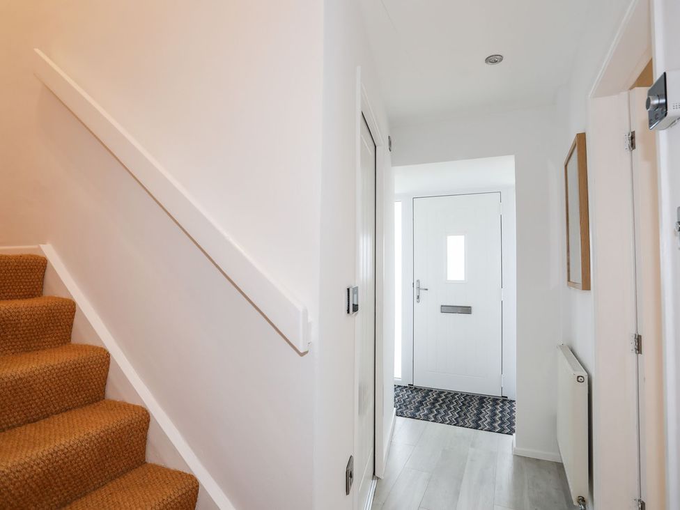 A hallway with stairs and a front door at 15 Llwyn Gwalch Estate Pwllheli
