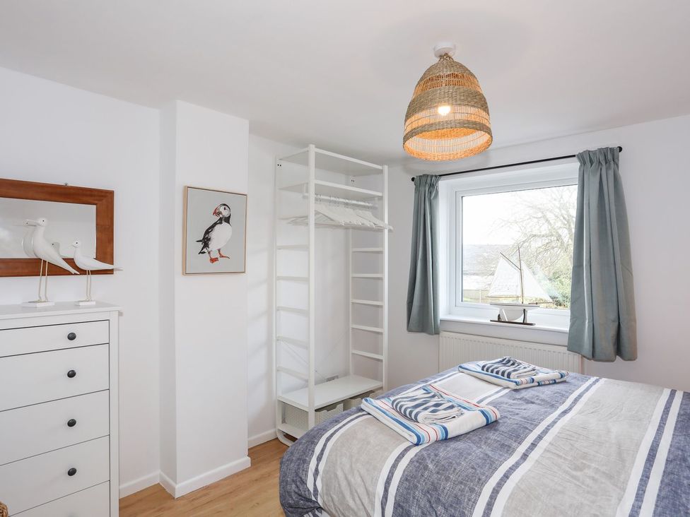 A bedroom with a bed and shelves at 15 Llwyn Gwalch Estate Pwllheli