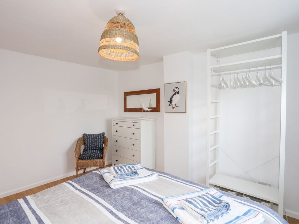 A bedroom with a bed and a chair at 15 Llwyn Gwalch Estate Pwllheli
