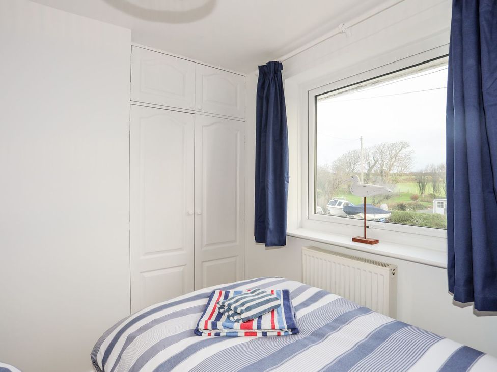 A bedroom with a bed and wardrobe at 15 Llwyn Gwalch Estate in Pwllheli
