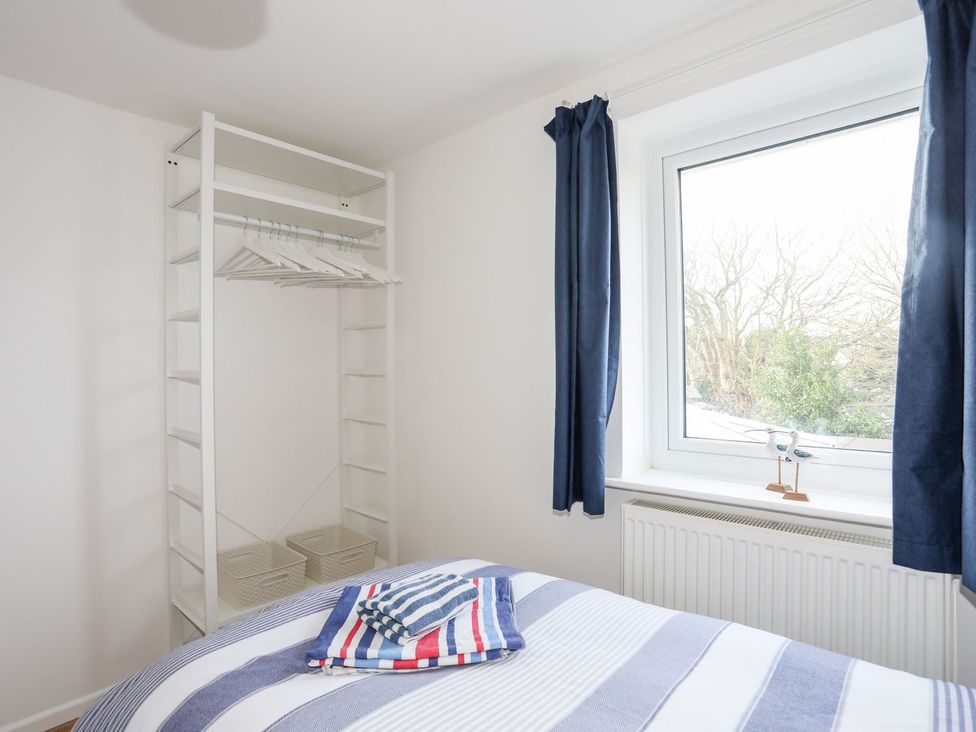 A bedroom with a bed and wardrobe at 15 Llwyn Gwalch Estate in Pwllheli