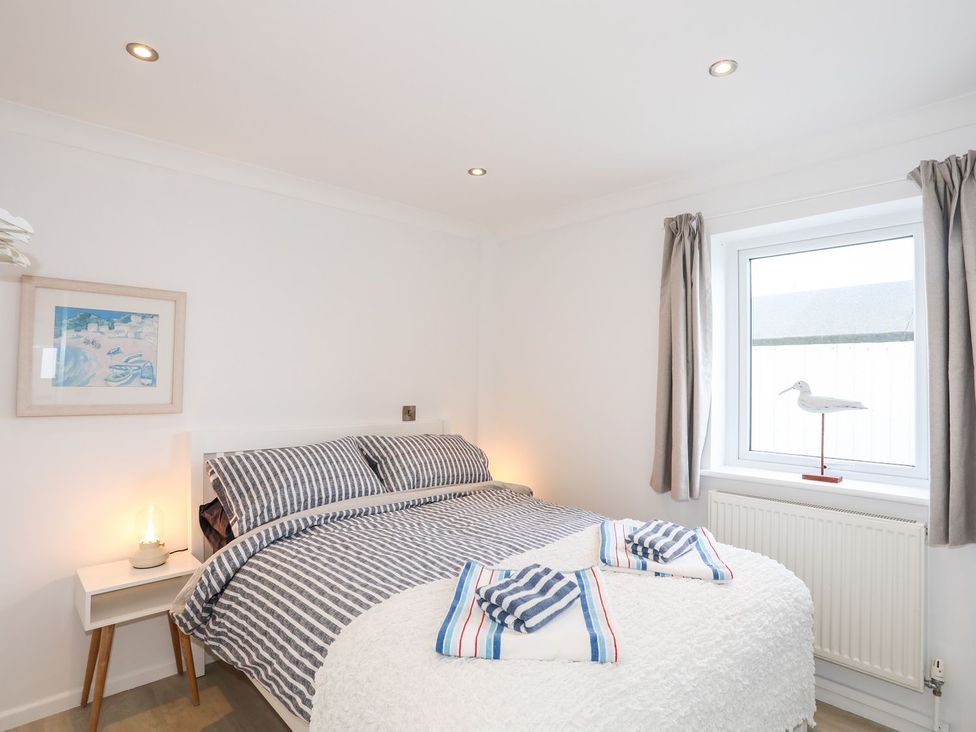 A bedroom with a bed and window at 15 Llwyn Gwalch Estate Pwllheli