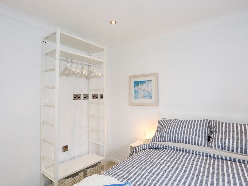 A bedroom with a bed and a wardrobe at 15 Llwyn Gwalch Estate in Pwllheli