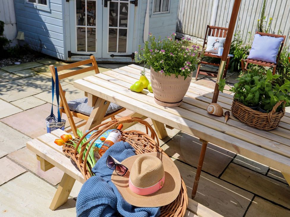 An outdoor dining area with a table and chairs at 15 Llwyn Gwalch Estate, Pwllheli