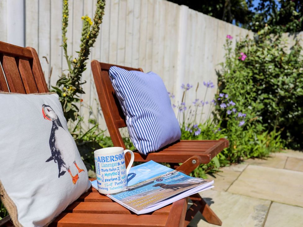 A garden with chairs and a magazine at 15 Llwyn Gwalch Estate Pwllheli