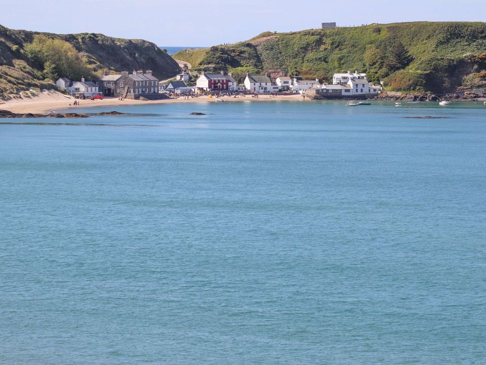 A view of a beach with houses and water at 15 Llwyn Gwalch Estate, Pwllheli