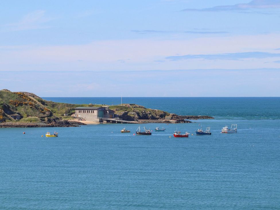 A view of fishing boats in water with a building on shore at 15 Llwyn Gwalch Estate in Pwllheli