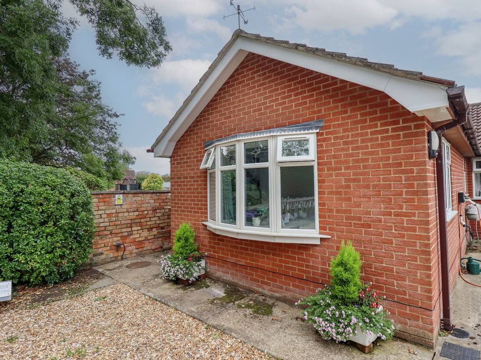 A brick exterior of a house with a window and flower pots at Southfields Annex in Little Carlton near Louth