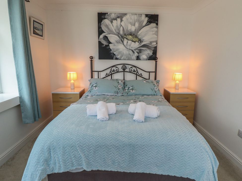 A bedroom with a bed, bedside tables, and wall art at Southfields Annex in Little Carlton near Louth