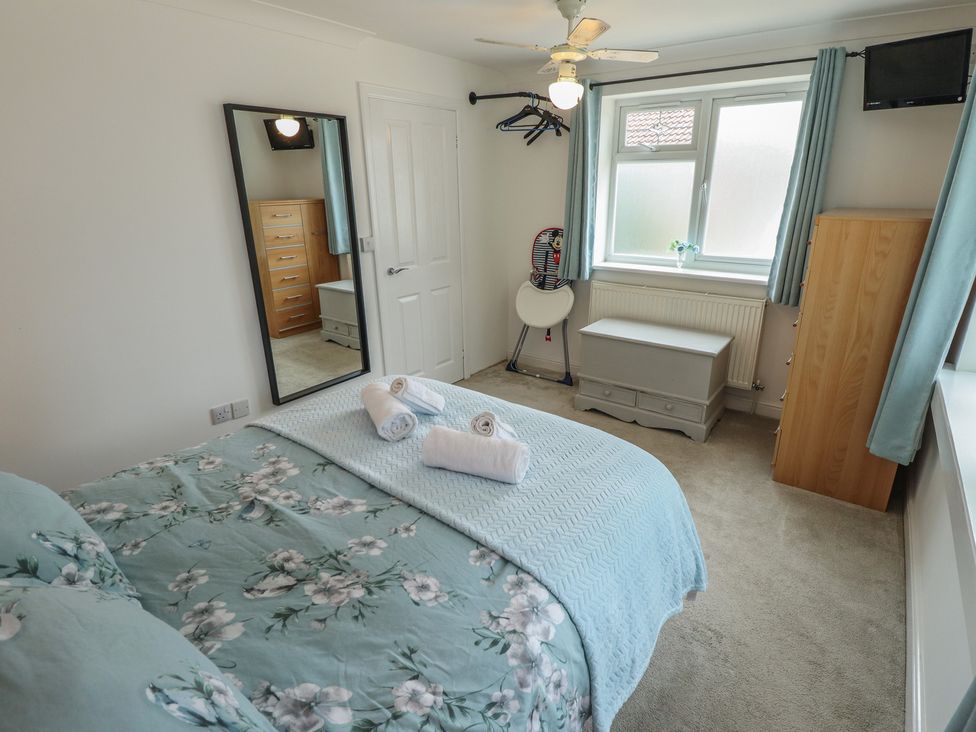 A bedroom with a bed, mirror, and wardrobe at Southfields Annex Little Carlton near Louth