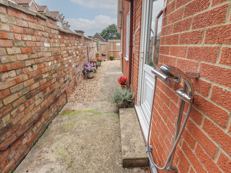 An outdoor space with a walkway and flower pots at Southfields Annex Little Carlton near Louth