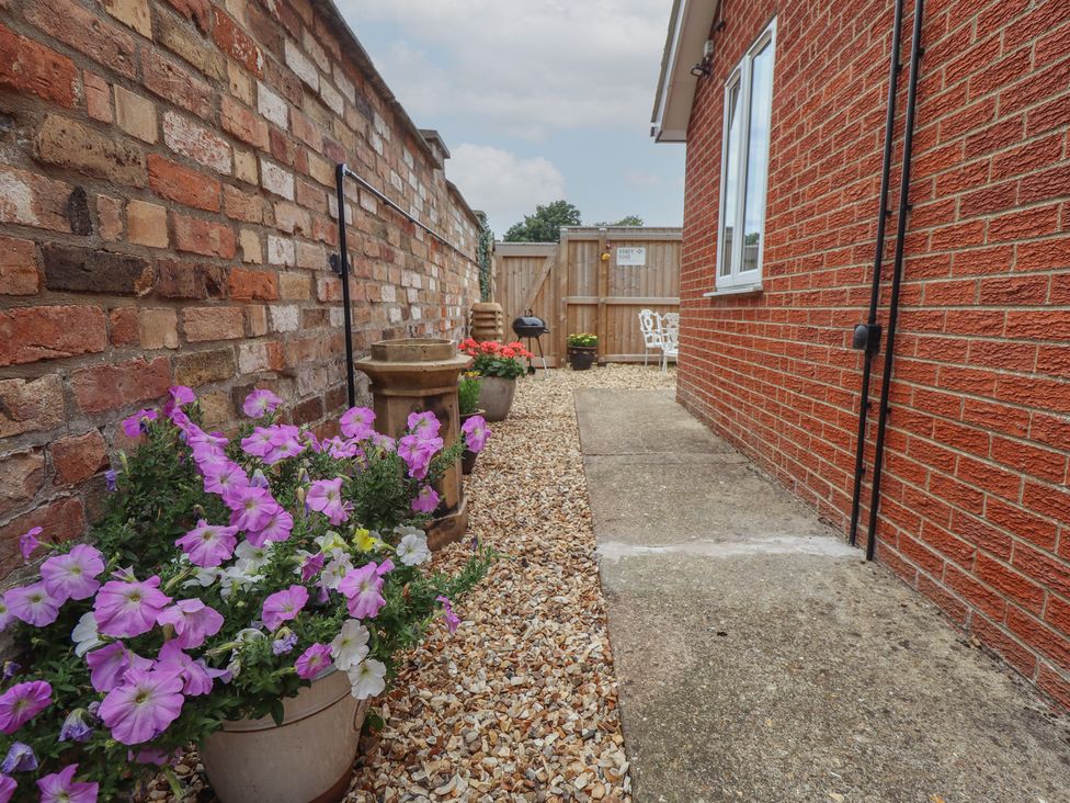 A pathway with flowers and garden furniture at Southfields Annex Little Carlton near Louth