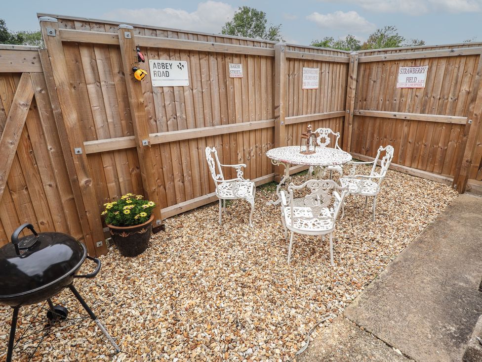 An outdoor seating area with a table and chairs at Southfields Annex Little Carlton near Louth
