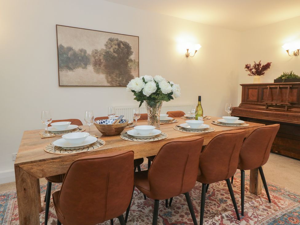 A dining room with a wooden table and chairs at Cumbria house