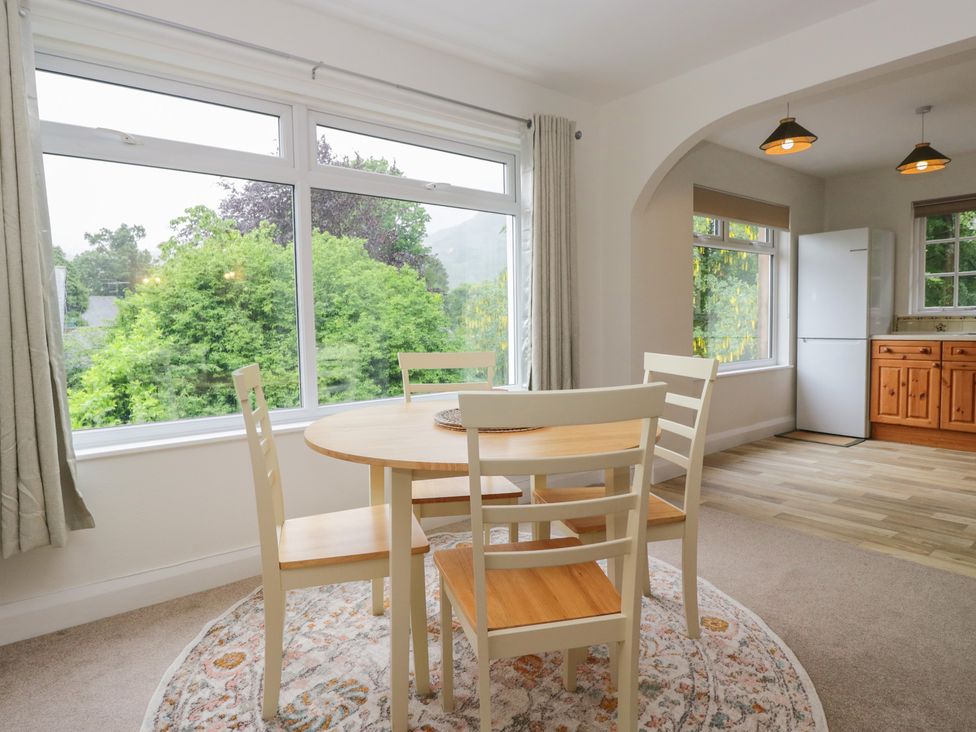 A dining area with a table and chairs and a refrigerator at Cumbria house