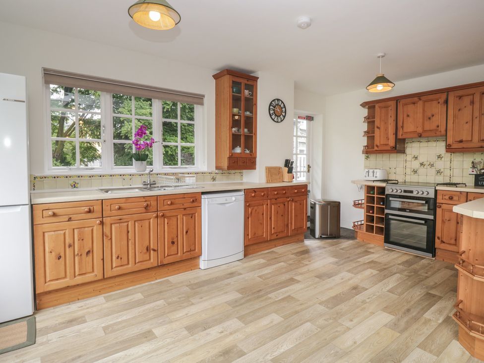 A kitchen with wooden cabinets and appliances at Cumbria house 